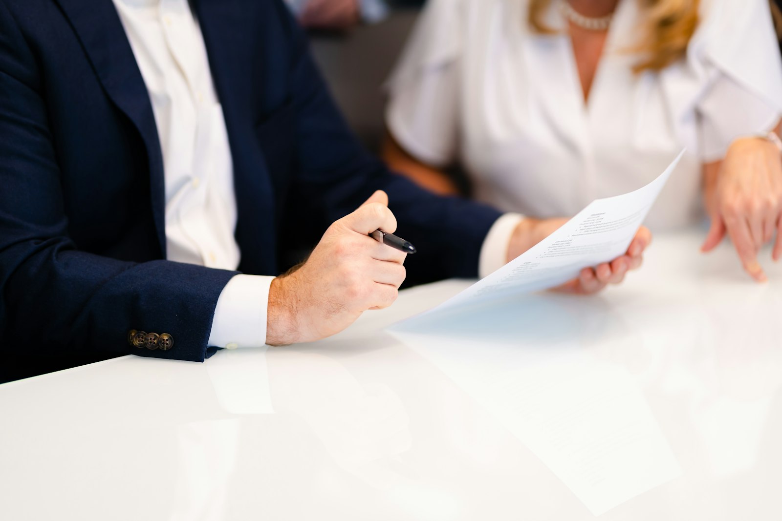 Two colleagues at a table reviewing a written quote document